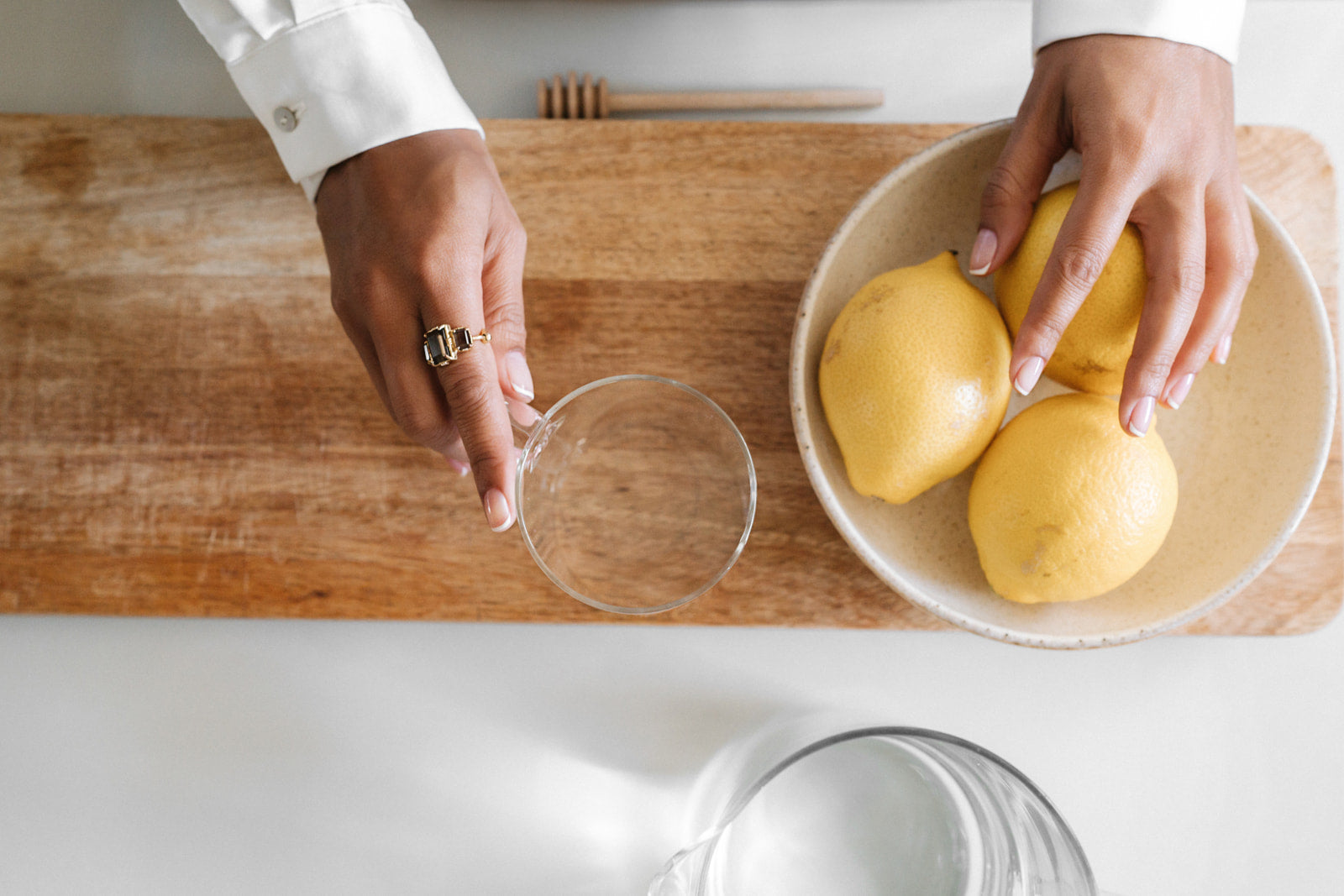 photo zoomée sur les mains d'une femme qui se prépare une citronnade dans le but de se faire un soin naturel des mains et des ongles sans ingrédients controversés dans son vernis à ongles