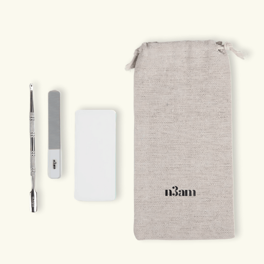 Kit de soin pour les ongles composé d'un coupe cuticule, d'une lime à ongles en verre, d'un tampon polissoir et d'un sac de transport en tissu